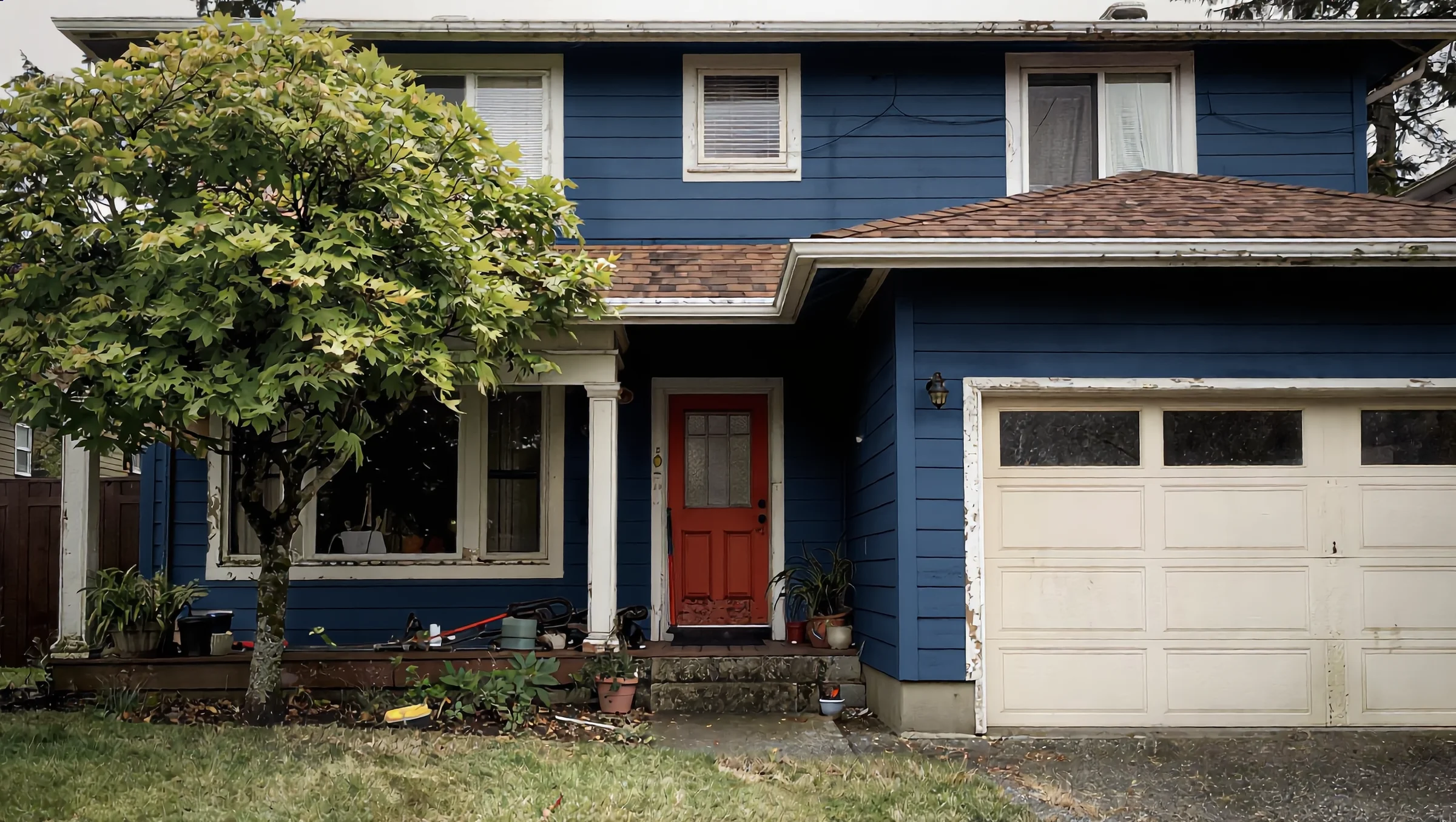 Two-story house repainted deep blue with a rust-red front door
